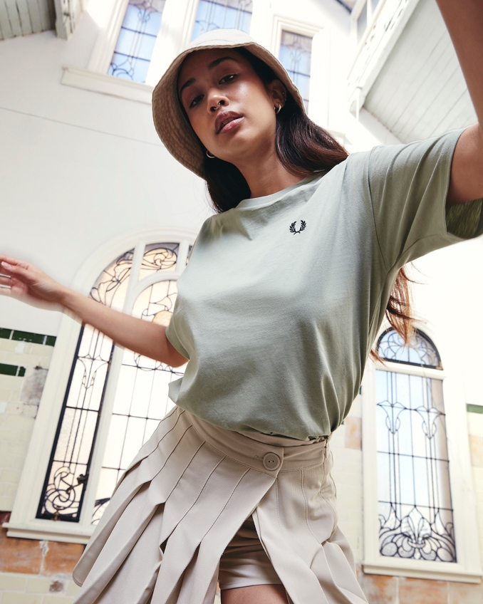 Mujer con camiseta Fred Pery y falda