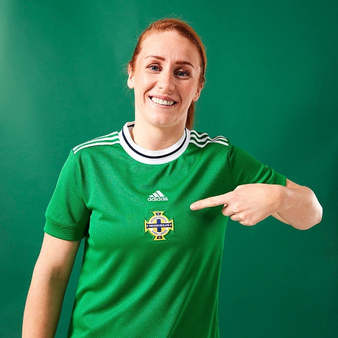 Rothaarige Frau im grünen Irland Trikot der EM 2022