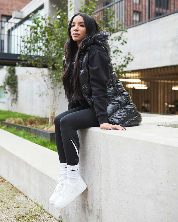 Nike Air Force 1 in Weiß, getragen von weiblichem Model in Nike Sportswear